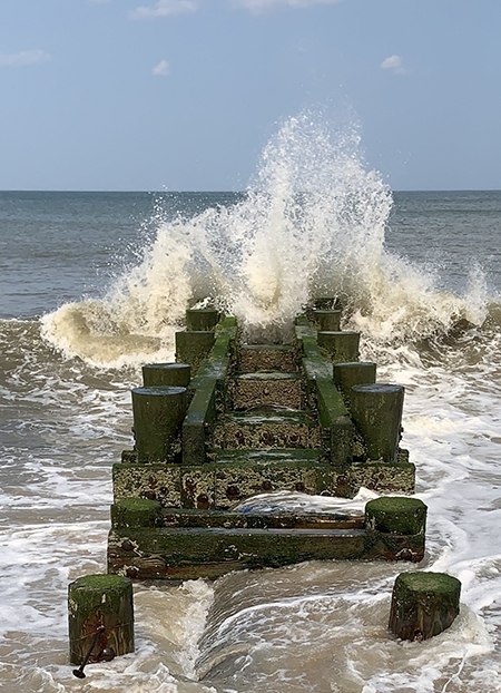 Wave breaking over breakwater.